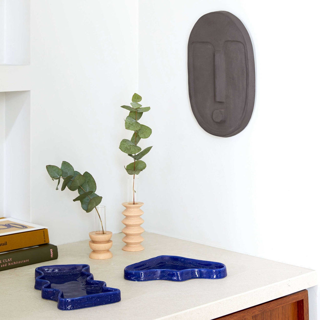 1. Lifestyle image of Totem Wooden Vase - Medium Nº 2 by 5mm Paper, styled with greenery on a modern shelf