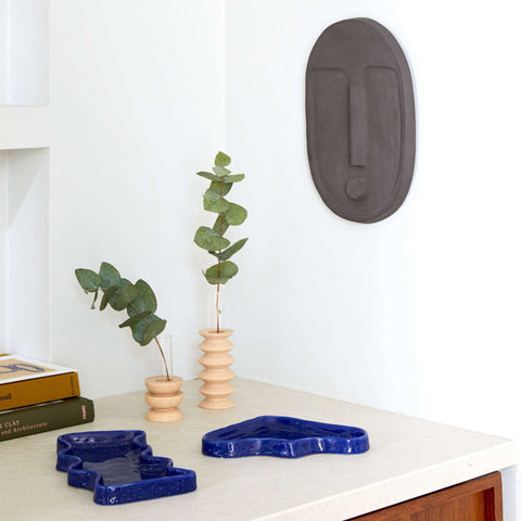 1. Lifestyle image of Totem Wooden Vase - Medium Nº 2 by 5mm Paper, styled with greenery on a modern shelf