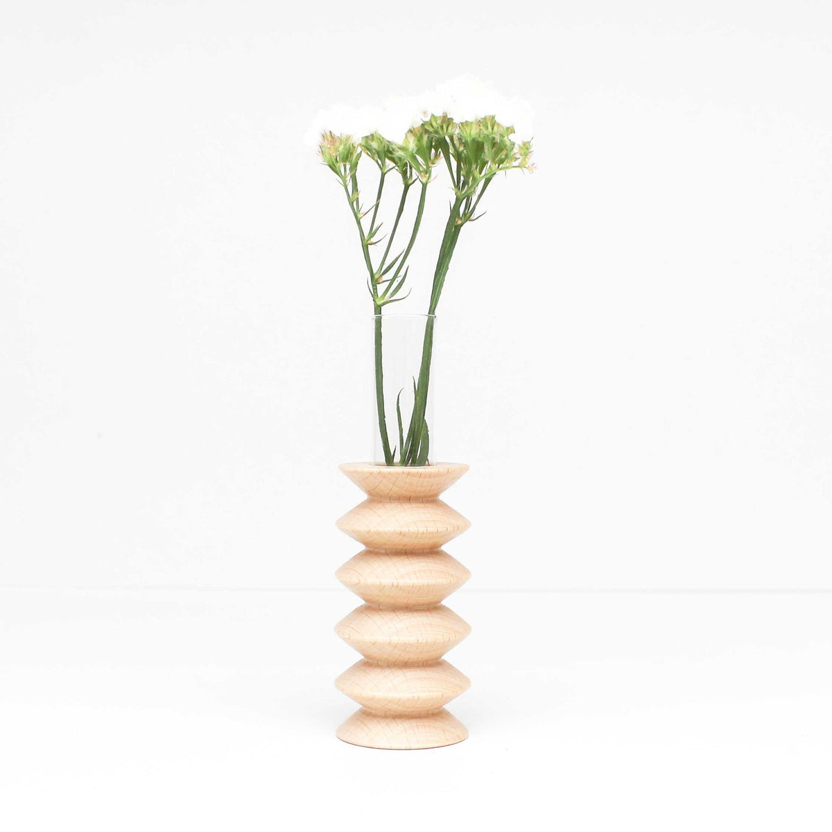 3. Studio shot of Totem Wooden Vase - Medium Nº 2 by 5mm Paper, featuring beech wood base and glass tube with flowers
