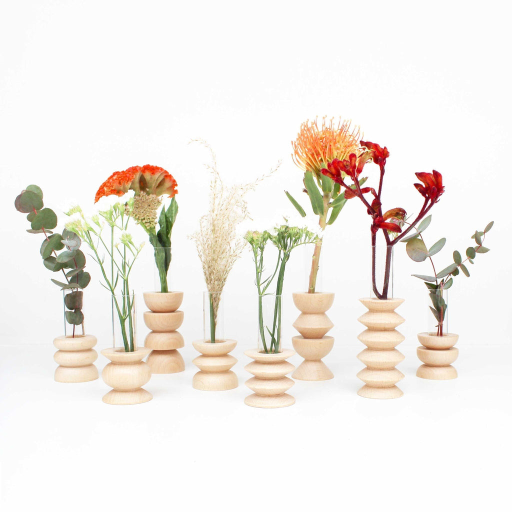 2. Collection of Totem Wooden Vases by 5mm Paper with various flowers, showcasing different sizes and designs