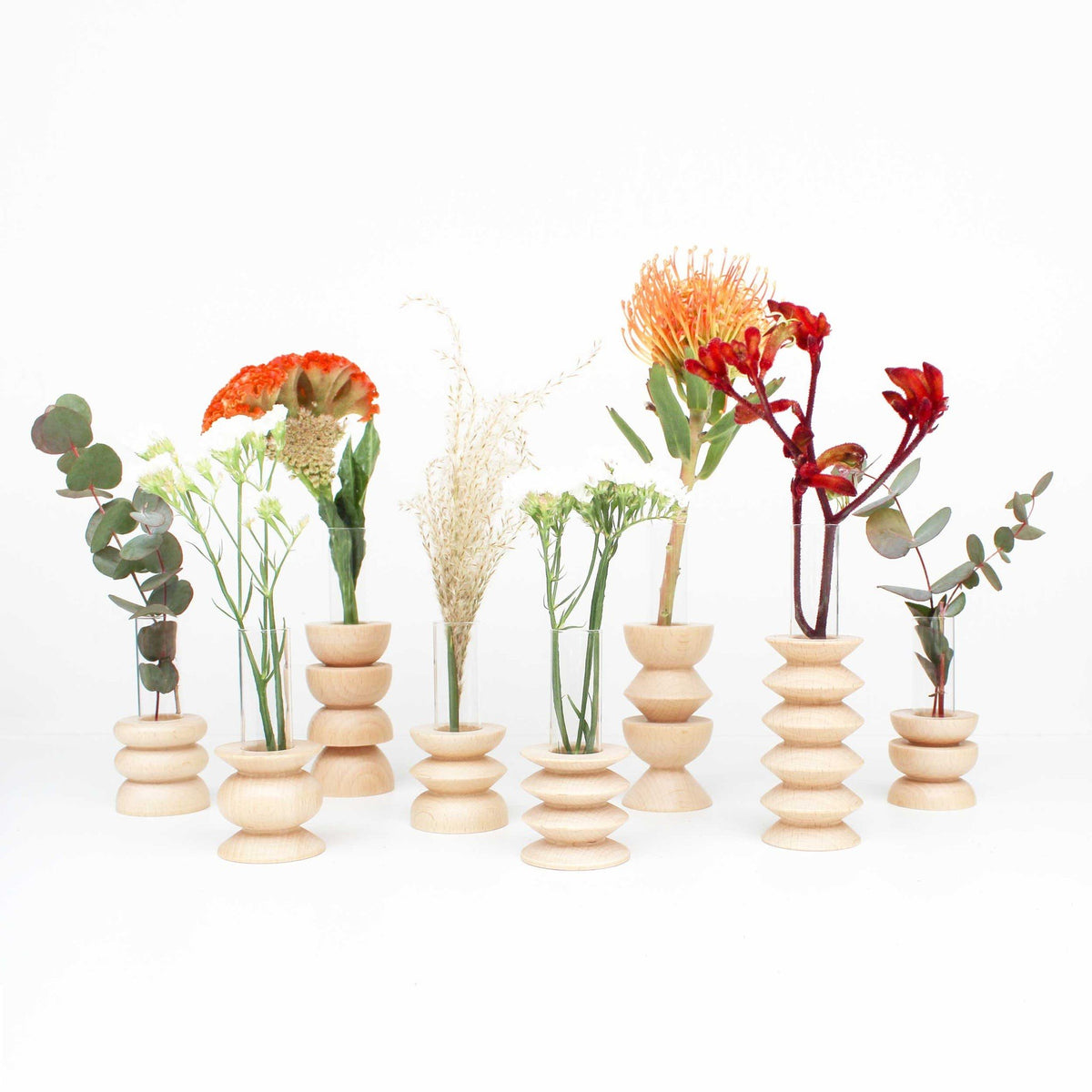 2. Collection of Totem Wooden Vases by 5mm Paper with various flowers, showcasing different sizes and designs