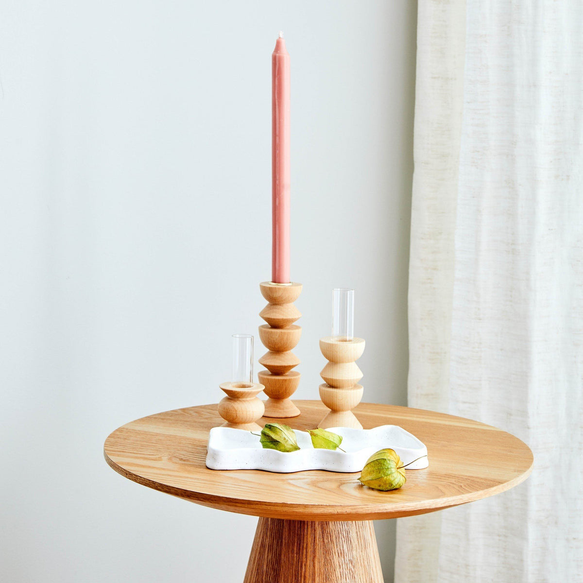1. Lifestyle image of Totem Wooden Vase - Short Nº 5 by 5mm Paper on a wooden table with candle holders, showcasing modern design and craftsmanship