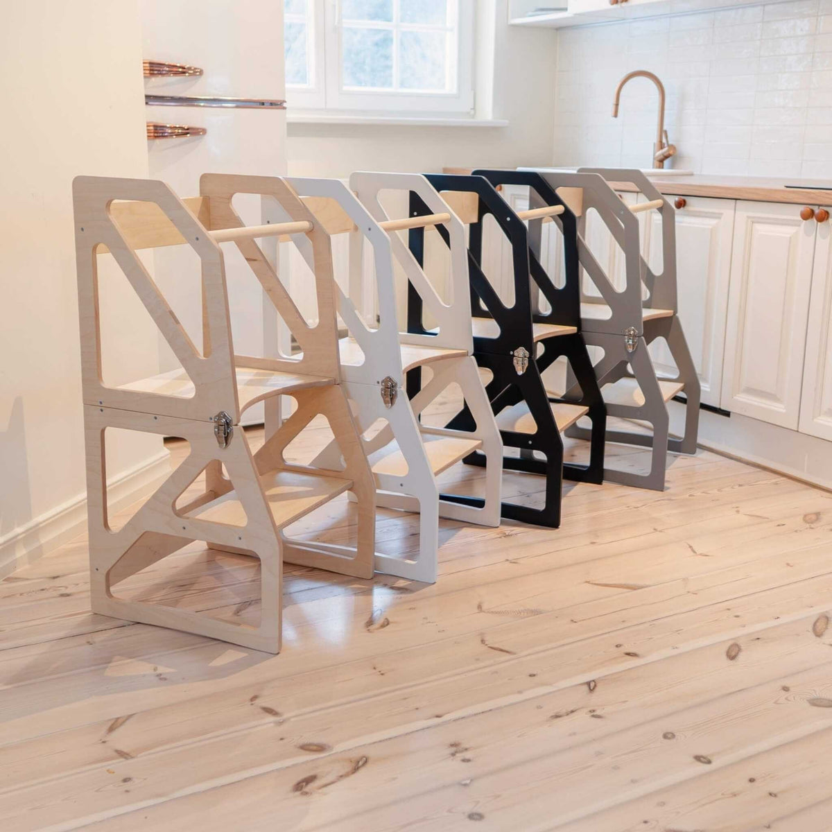 1. Four transformable kitchen towers in natural, white, black, and gray colors lined up in a modern kitchen