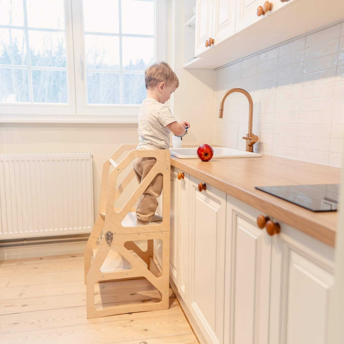 1. Toddler using natural birch kitchen tower at sink in bright kitchen