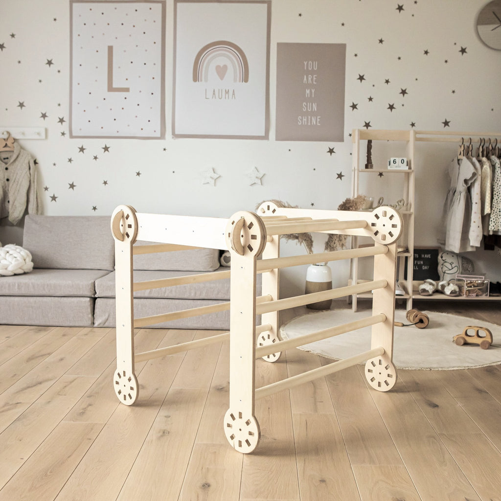 1. Indoor lifestyle shot of transformable Montessori climber in natural wood finish, set in a children's playroom with wooden floor and decor