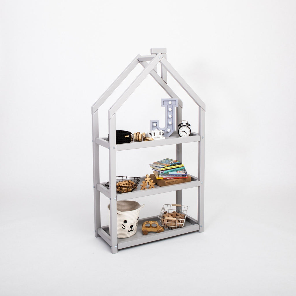 3. Grey house-shaped shelf in studio setting with books and decor items