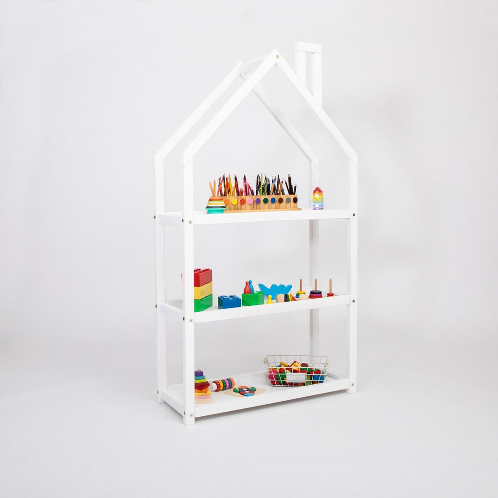 3. White house-shaped shelf in studio setting with colorful toys and books