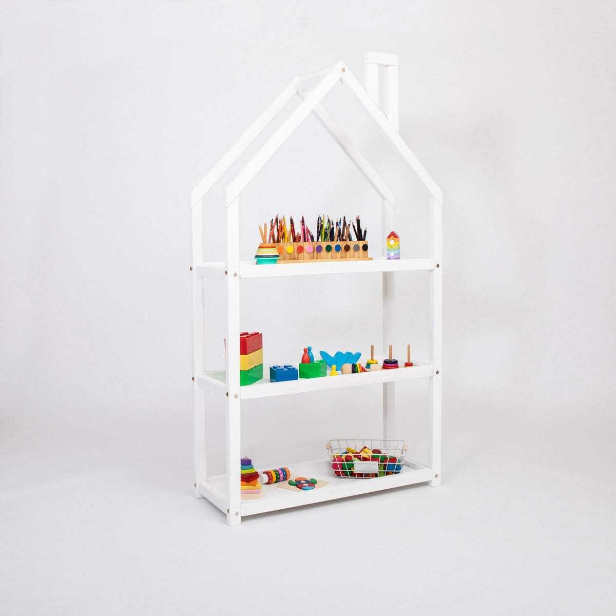 3. White house-shaped shelf in studio setting with colorful toys and books