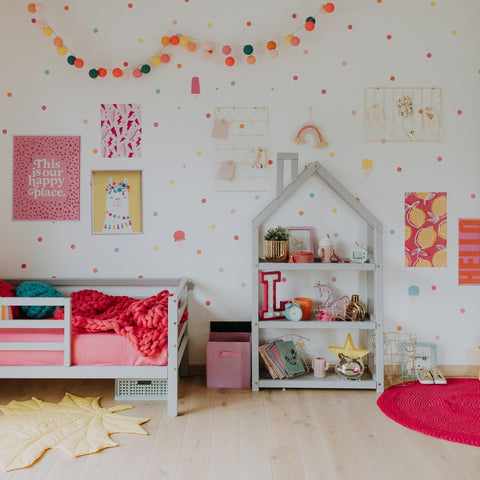 1. Grey house-shaped shelf in colorful children's room with pink bed and wall decor