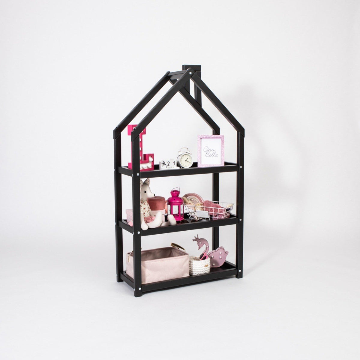 3. Black house-shaped shelf in studio setting with pink and white decor items