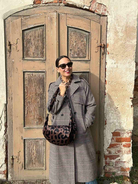 2. Woman wearing Garbanota Classic Leopard Hobo Bag outdoors, styled with a plaid coat