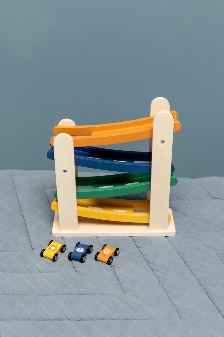 3. Trixie Baby wooden race track with animal cars on a blue quilted surface