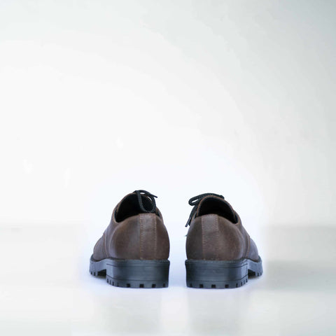 3. Back view of unisex dark brown Samelin Widgets shoes, highlighting sturdy construction, studio setting