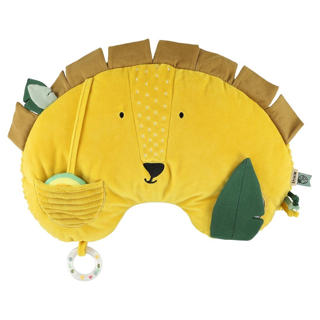 2. Front view of Trixie Baby's Mr. Lion tummy time pillow in yellow with green leaf and rattle, featuring a lion face design on a clean white background