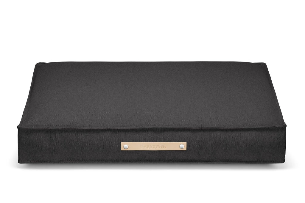 2. Labbvenn Töve cushion in anthracite with leather handle, shown in studio setting highlighting minimalist design