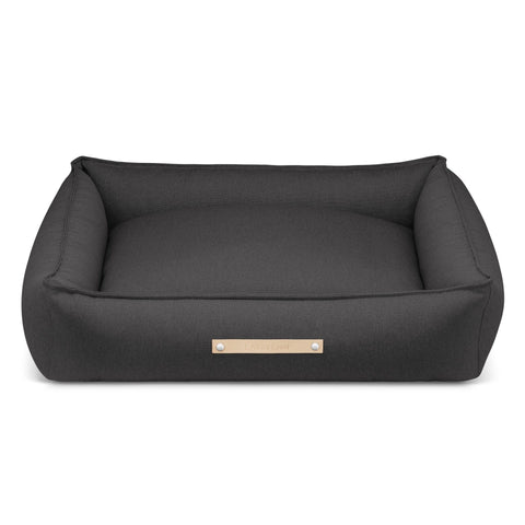2. Anthracite Töve dog bed by Labbvenn with high sides and elongated shape, featuring a leather belt and embossed logo, shown in a studio setting