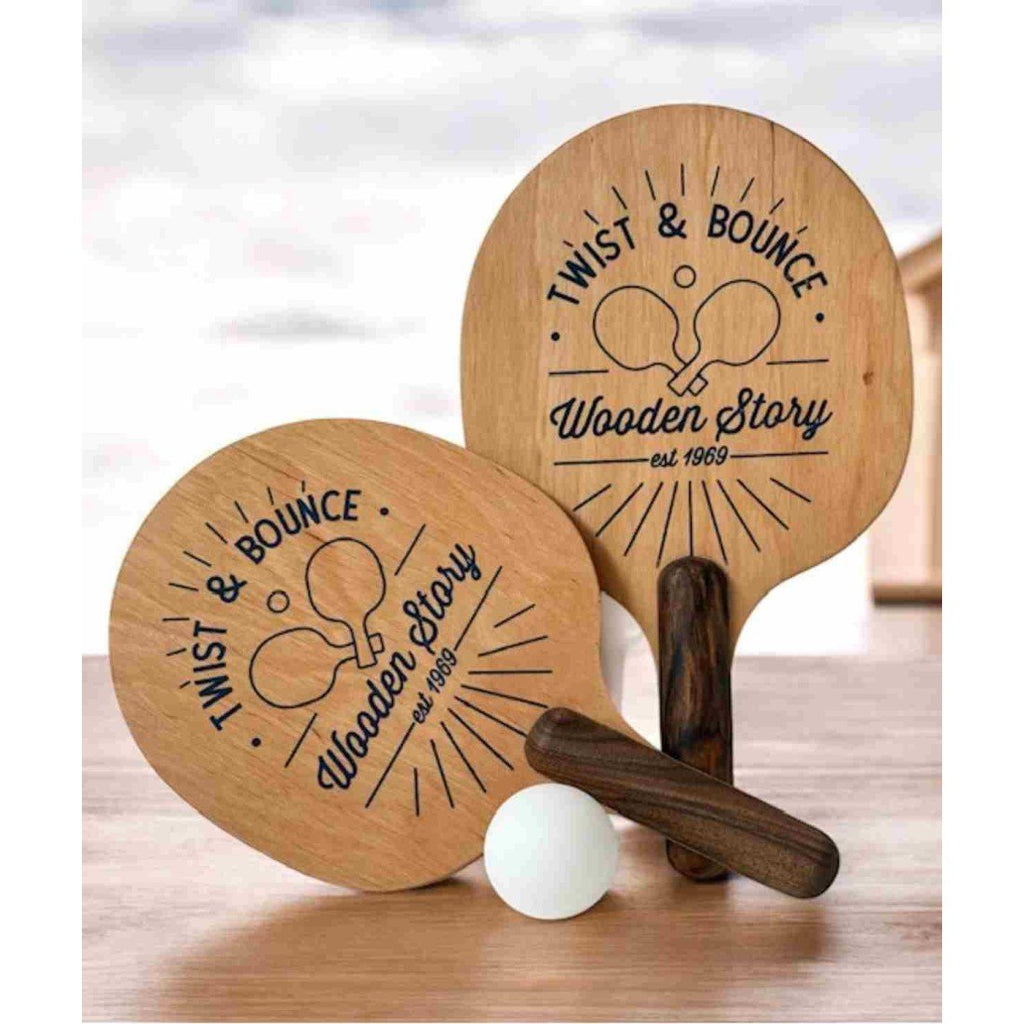 3. Two wooden ping pong paddles with 'Twist & Bounce' logo and a white ball on a wooden surface