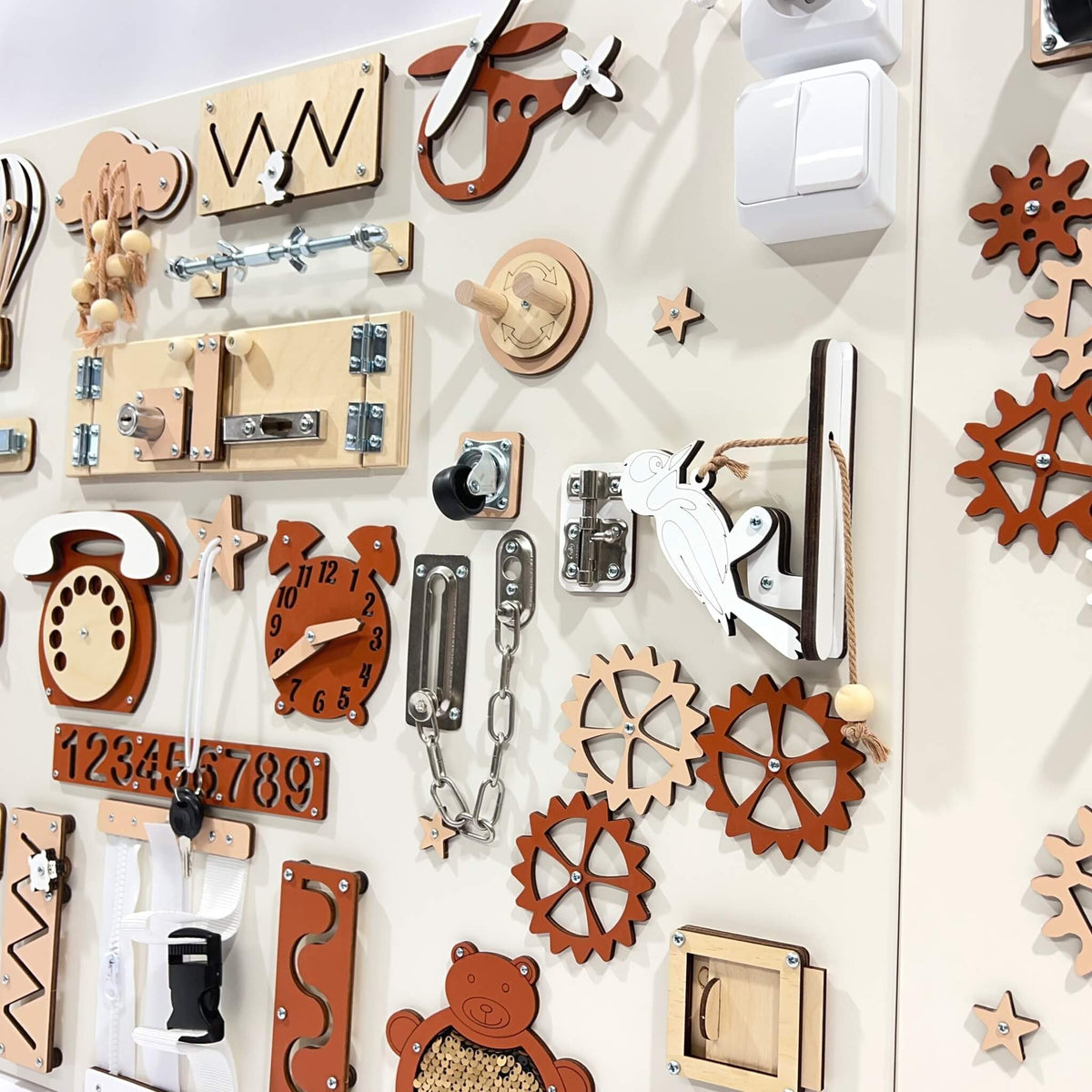 4. Close-up of red and beige wall activity panel showing detailed interactive elements like gears and locks for children's play.