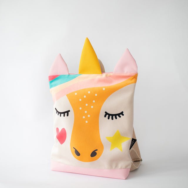 11. Studio shot of MUNI Unicorn backpack, highlighting unicorn face design and pink polyester bottom