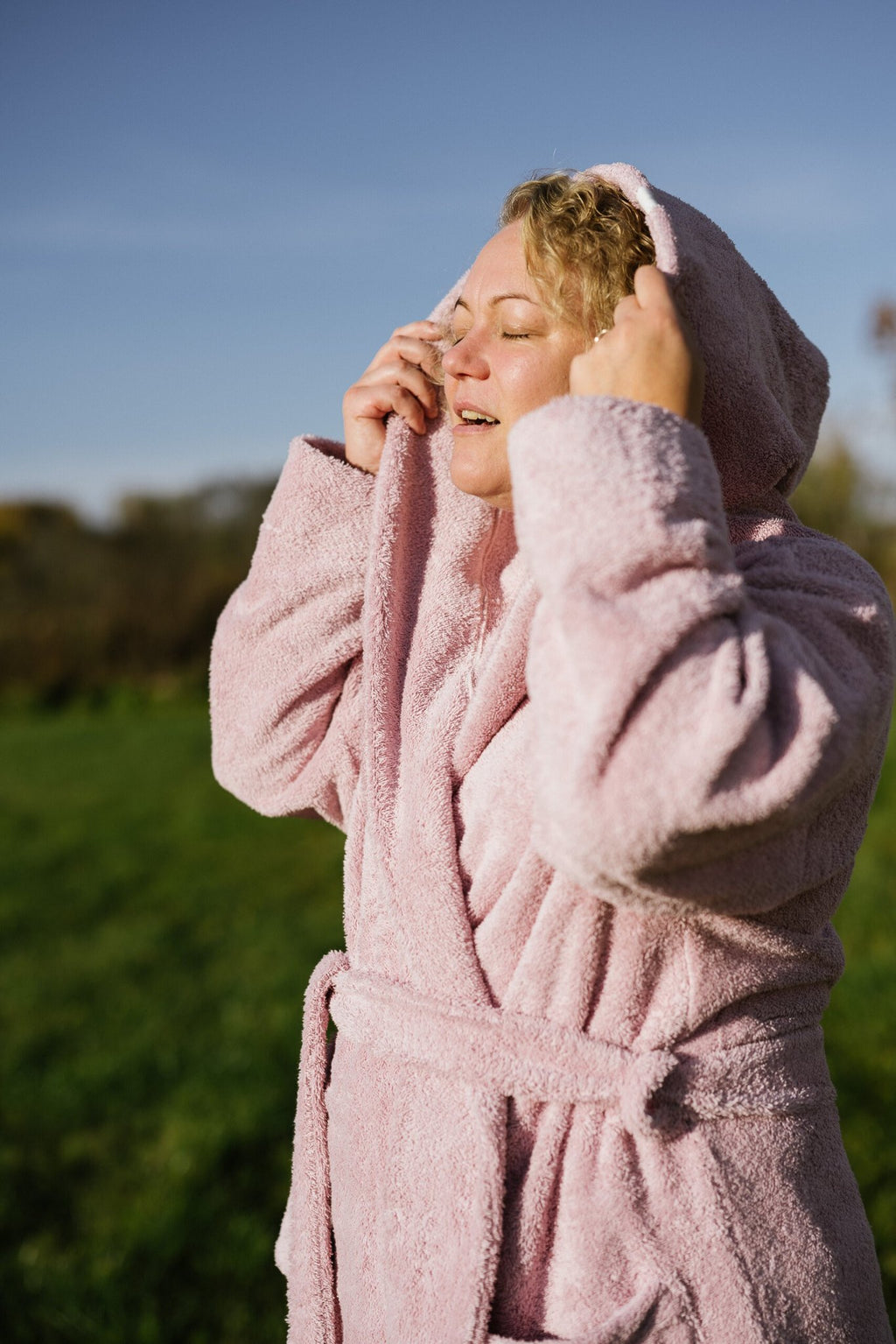 6. Woman enjoying the sun in pink RÄTT hooded bathrobe, highlighting comfort