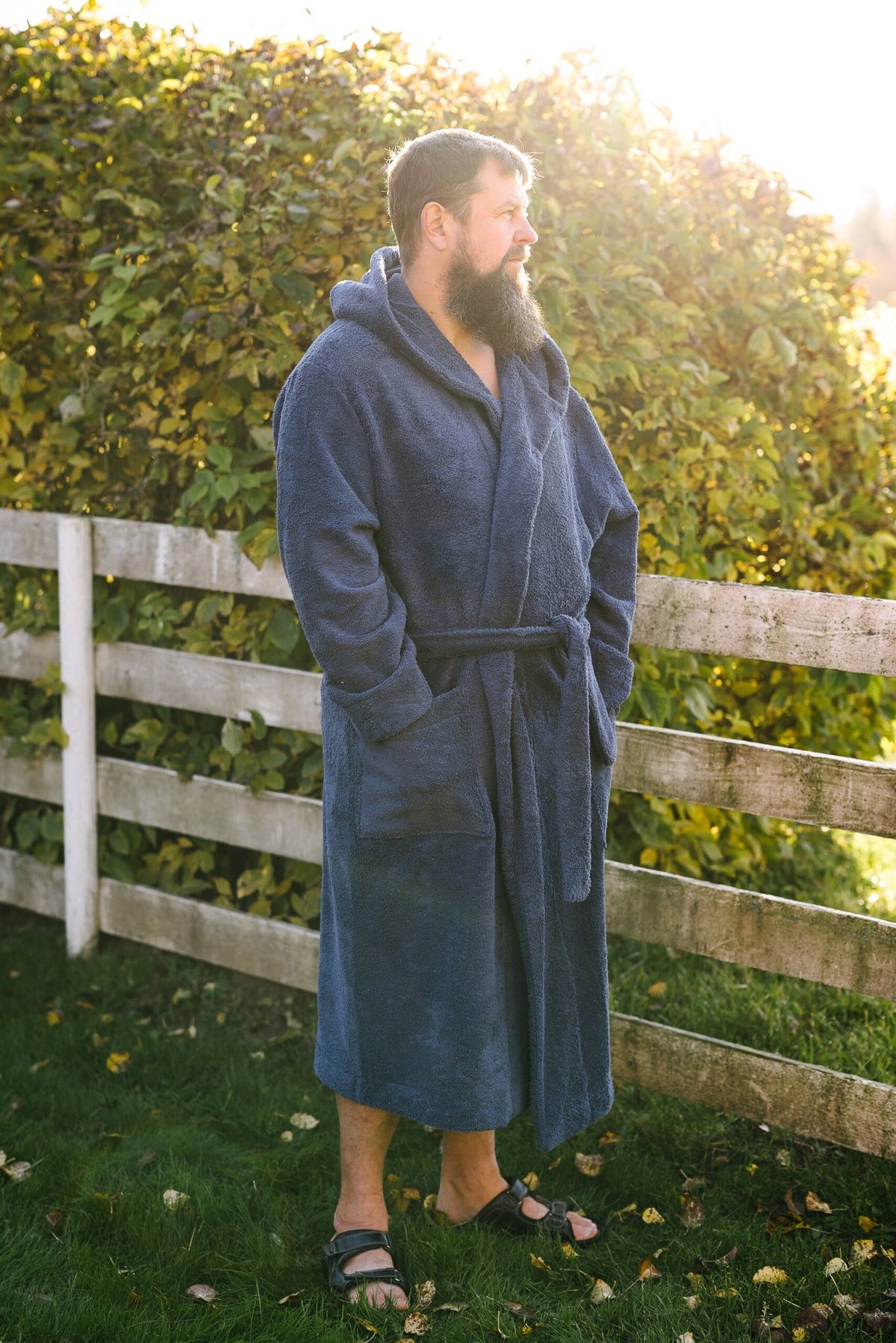 5. Man wearing blue RÄTT hooded bathrobe outdoors, showcasing fit and style
