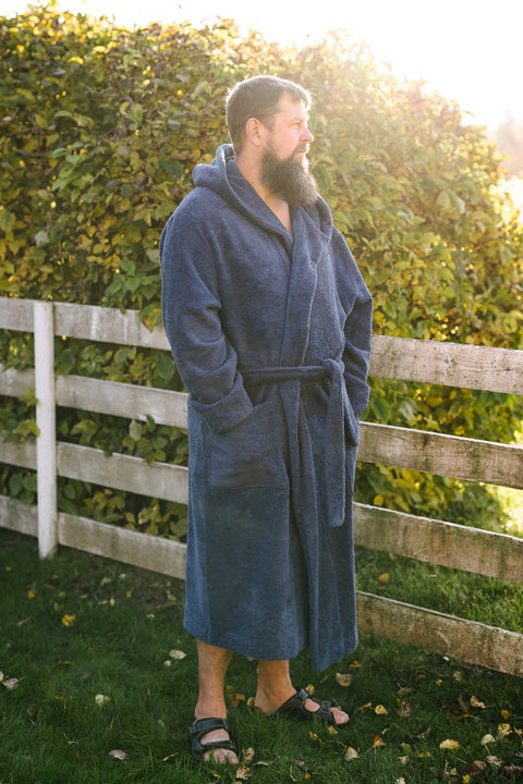 5. Man wearing blue RÄTT hooded bathrobe outdoors, showcasing fit and style