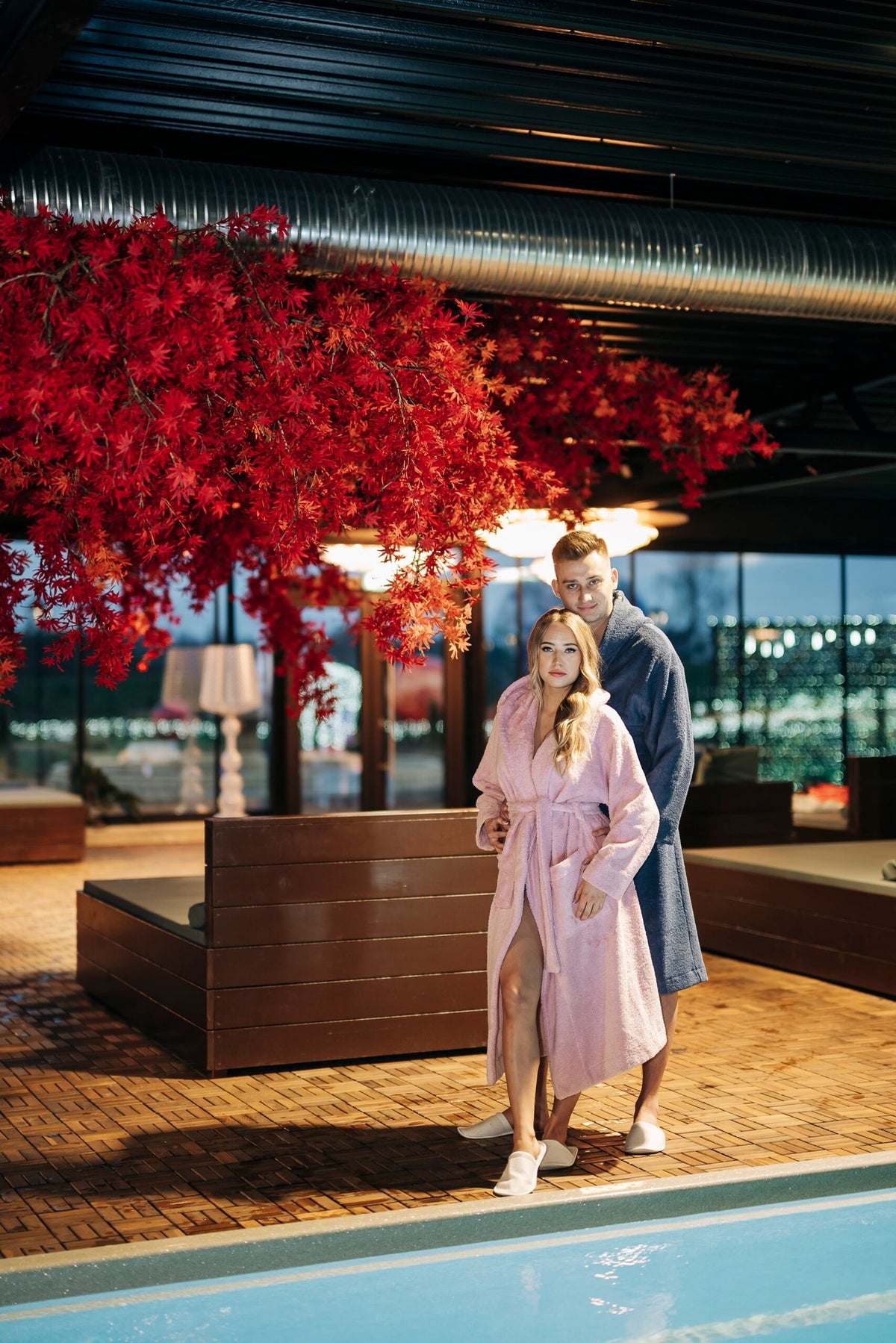 1. Unisex hooded bathrobes by RÄTT worn by male and female models by the poolside