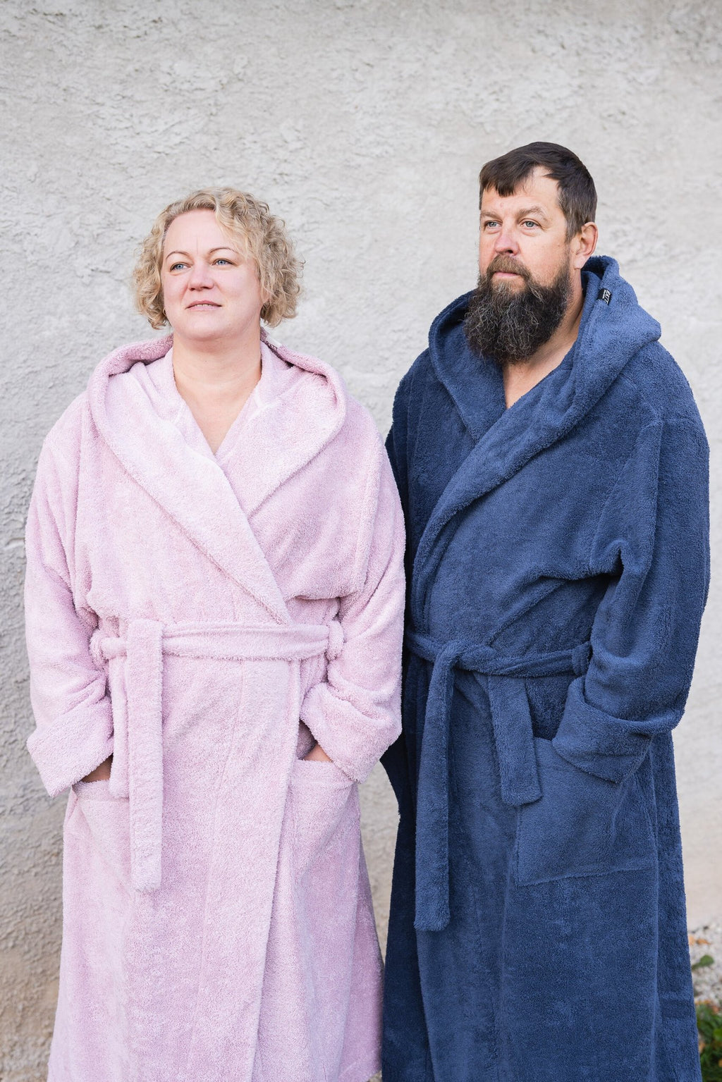8. Unisex RÄTT bathrobes in pink and blue worn by couple against a neutral background