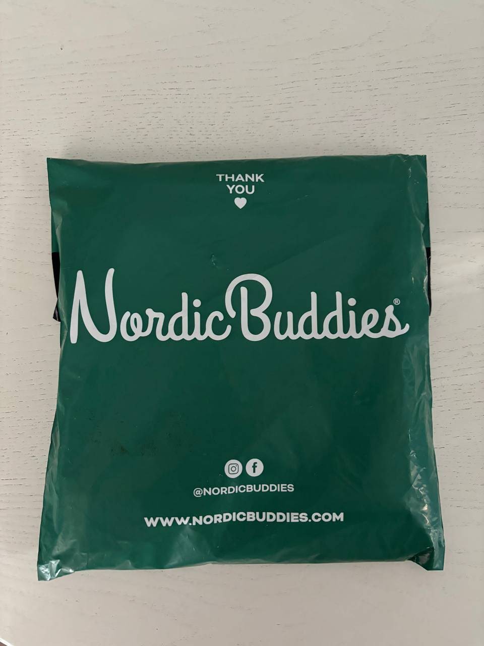 Green package with 'Nordic Buddies' branding on a light gray background