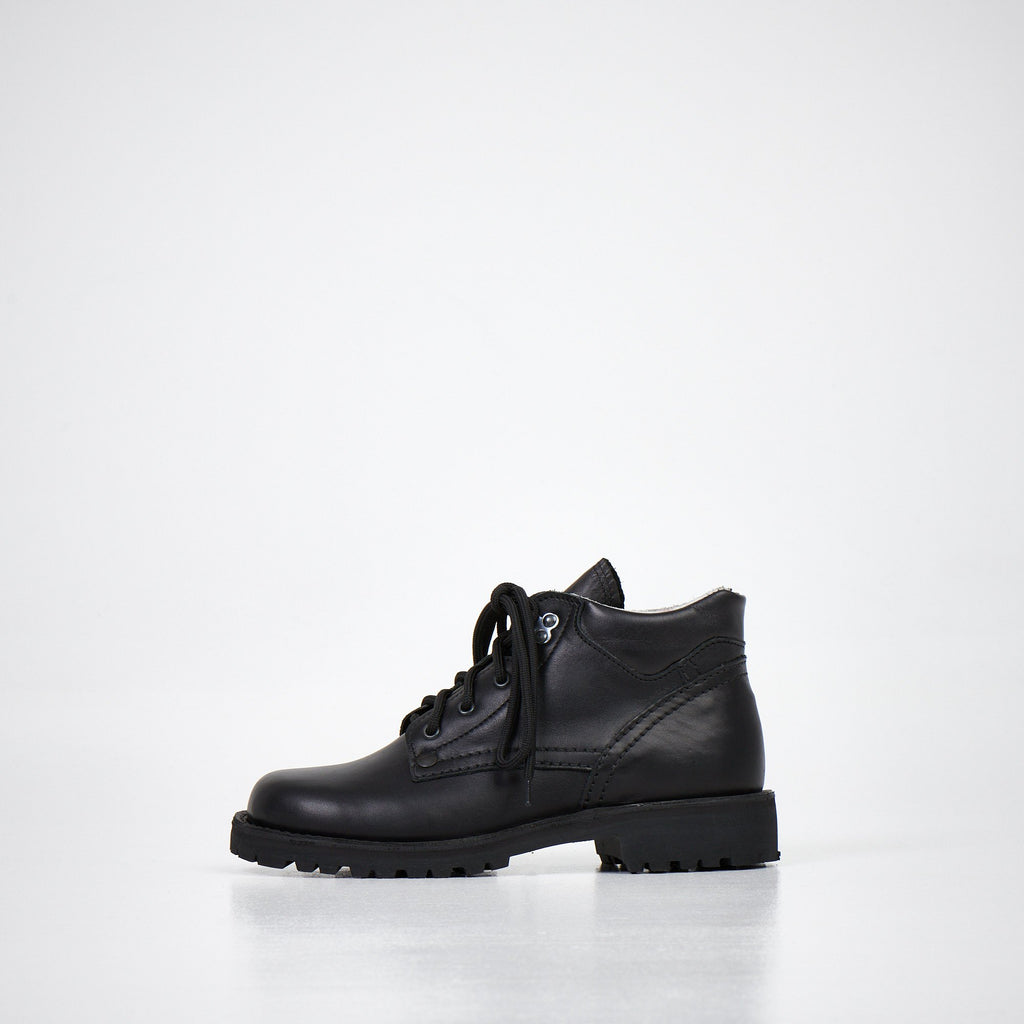 4. Side angled view of AIPI Handmade Ankle Boots in black leather, emphasizing the natural leather texture and stitching