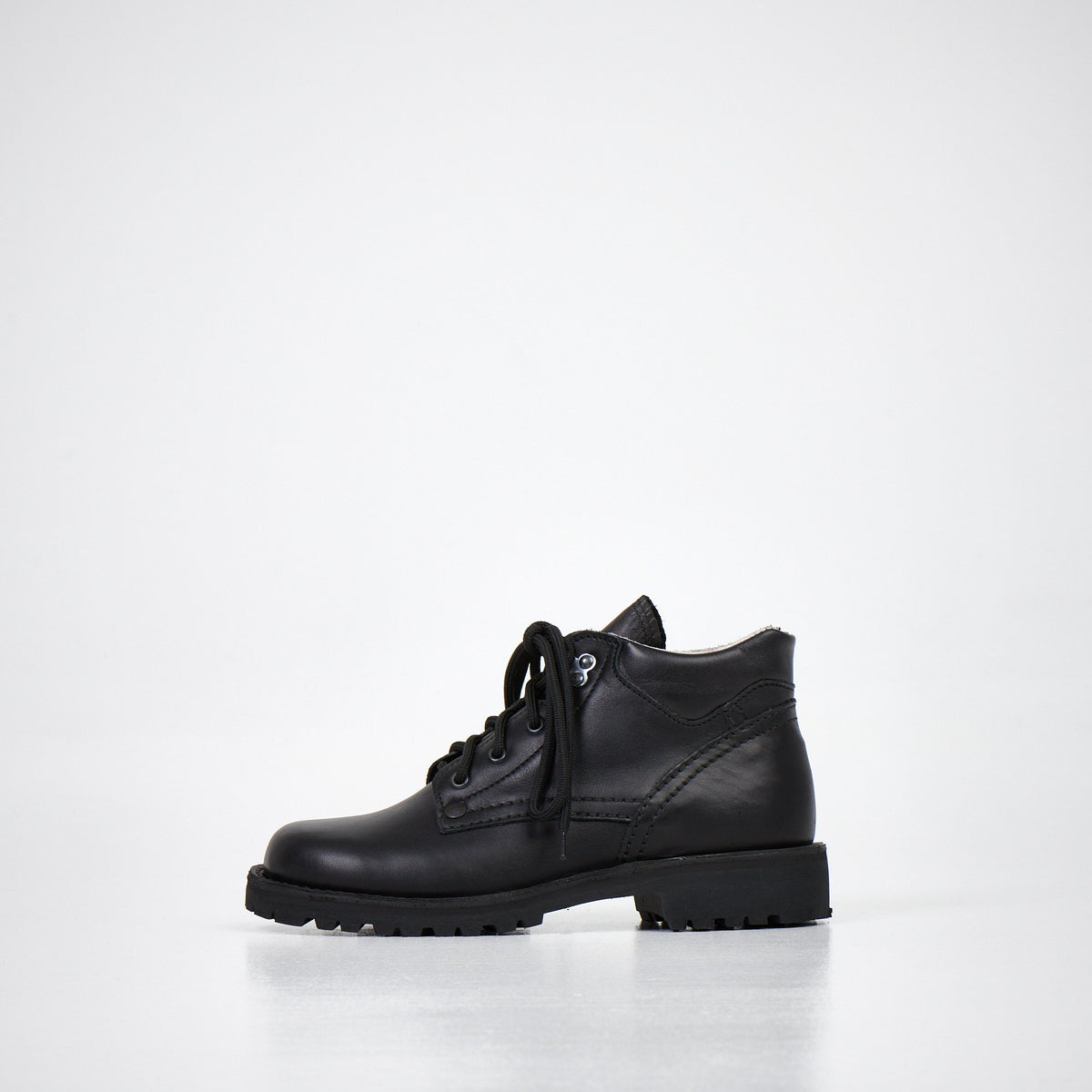 4. Side angled view of AIPI Handmade Ankle Boots in black leather, emphasizing the natural leather texture and stitching