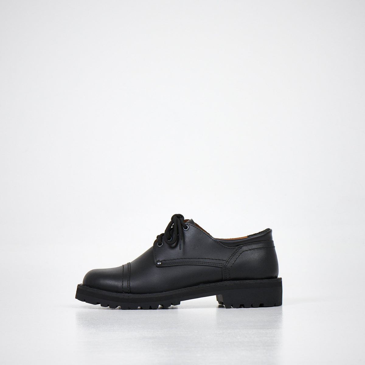 1. Unisex AIPI handmade leather shoes in black, side view showcasing durable stitched-through soles and rubber outsole, studio setting