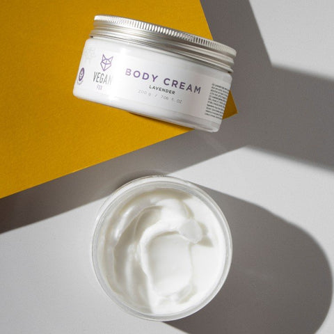 3. Open jar of Vegan Fox Lavender Body Cream on yellow background, showing creamy texture