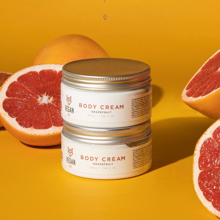 1. Vegan Fox Grapefruit Body Cream in 200g jars with fresh grapefruit halves on a vibrant yellow background