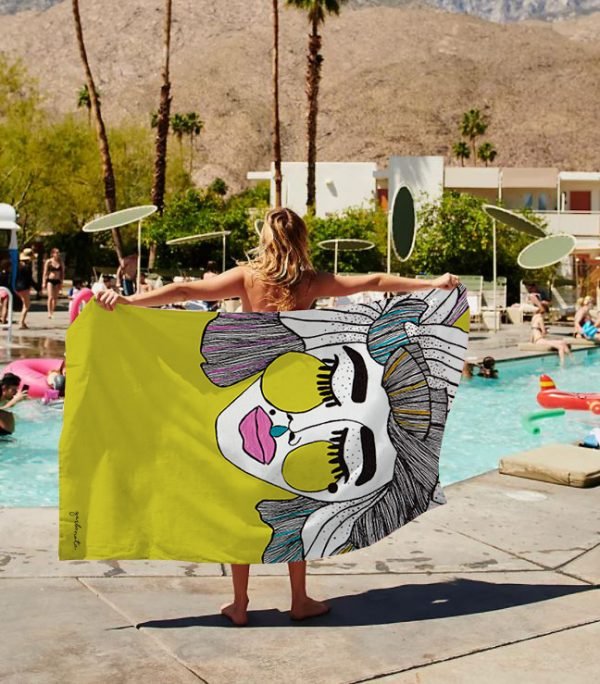 1. Woman holding Garbanota Towel Veronika in yellow by the pool, showcasing hand-drawn design