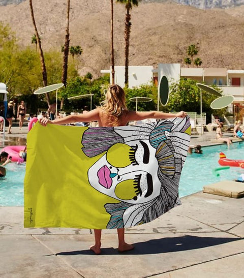 1. Woman holding Garbanota Towel Veronika in yellow by the pool, showcasing hand-drawn design