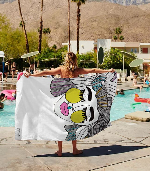 2. Woman holding Garbanota Towel Veronika with artistic face design by a poolside