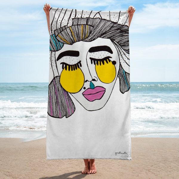 1. Garbanota Towel Veronika in white with artistic face design held by a person on a beach