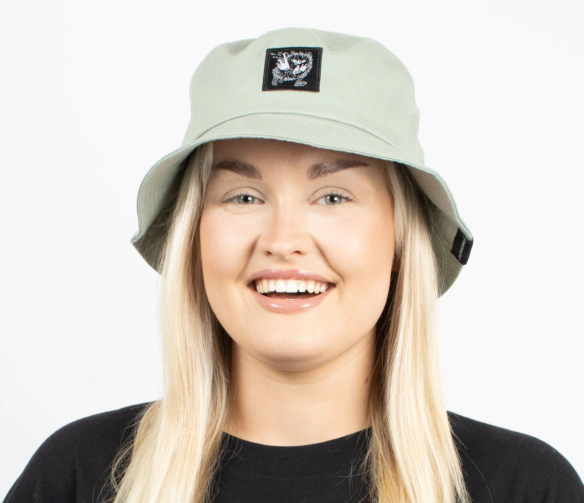 2. Woman wearing light green Stinky Bucket Hat by Moomin, shown from the side in studio