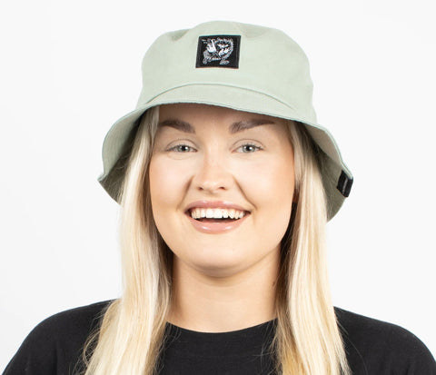2. Woman wearing light green Stinky Bucket Hat by Moomin, shown from the side in studio