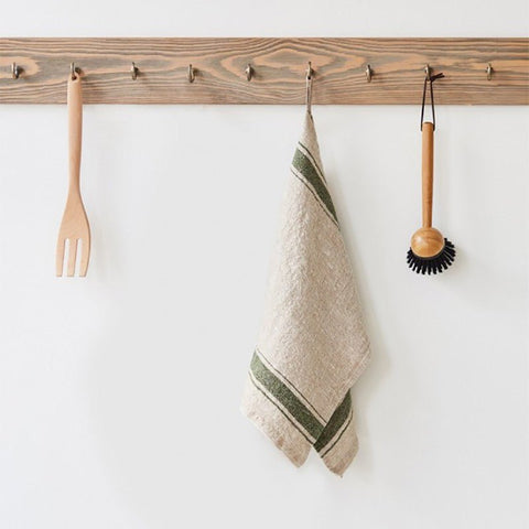 1. Beige linen kitchen towel with green stripes hanging on wooden rack with utensils