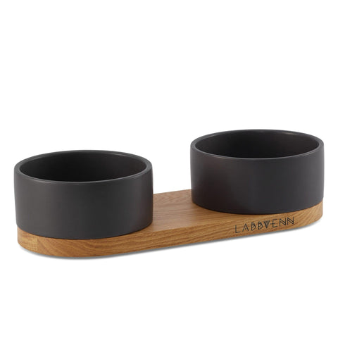 2. Black ceramic double pet buffet with oak wood base by Labbvenn, featuring two round bowls for feeding and watering, ideal for stylish home interiors.