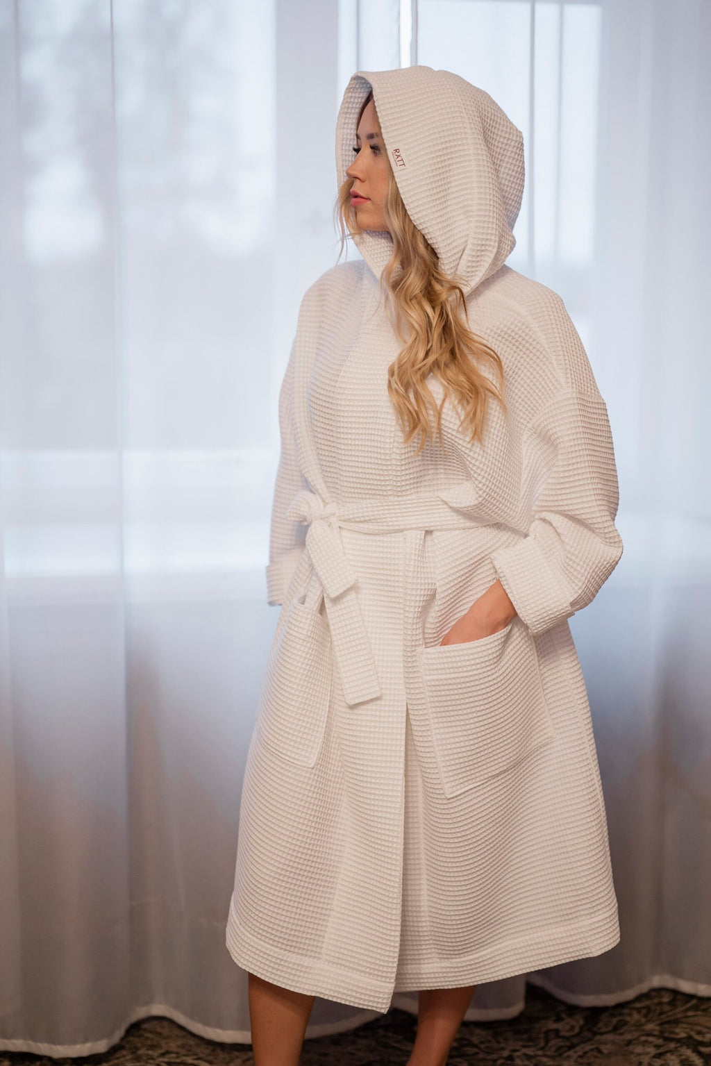 3. Women's white waffle cotton robe with hood shown in a cozy indoor setting