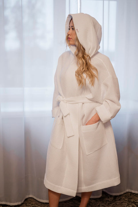 3. Women's white waffle cotton robe with hood shown in a cozy indoor setting