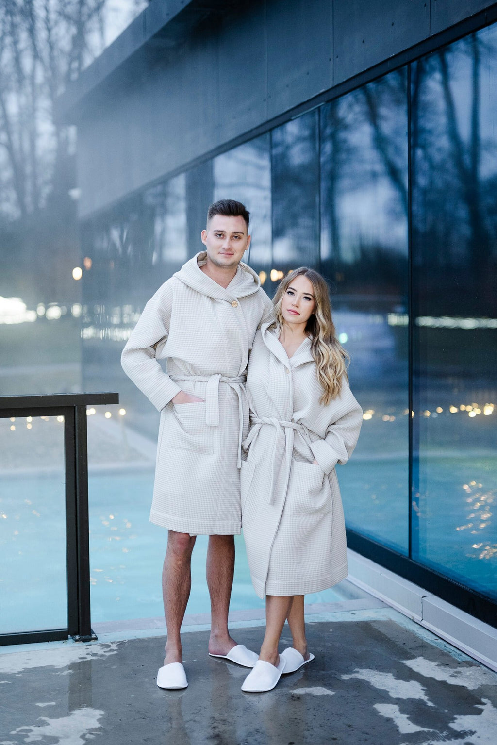1. Unisex white waffle cotton robes with hood worn by male and female models outdoors