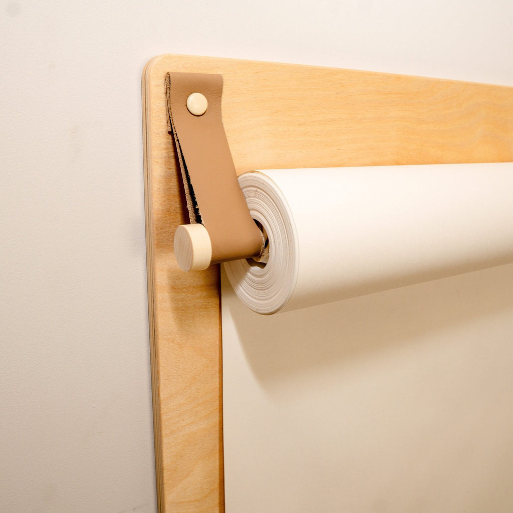 3. Close-up of paper roll holder on wooden wall-mounted drawing board