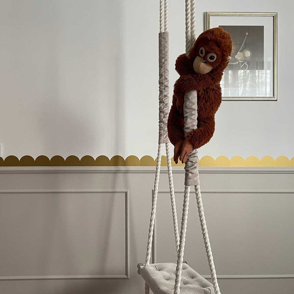 2. Golden circle wall stickers in a room with a hanging plush monkey and framed artwork