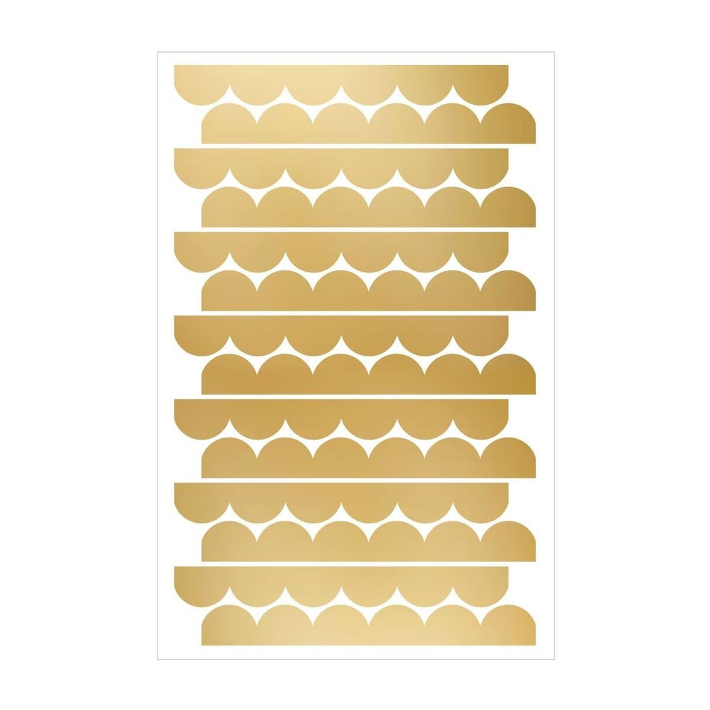 7. Flat lay of golden circle wall stickers arranged in stripes on a white background