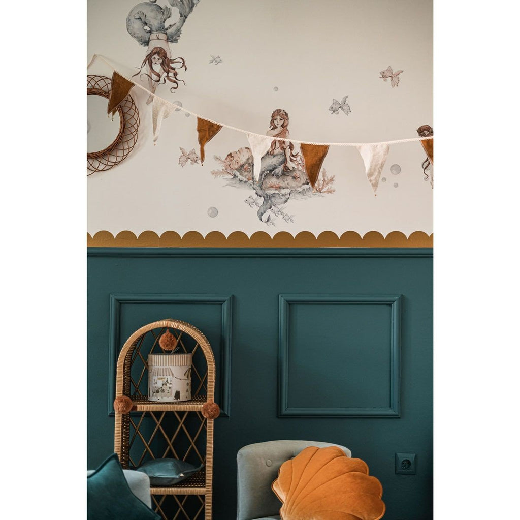 6. Room with golden circle wall stickers, teal paneling, and decorative bunting