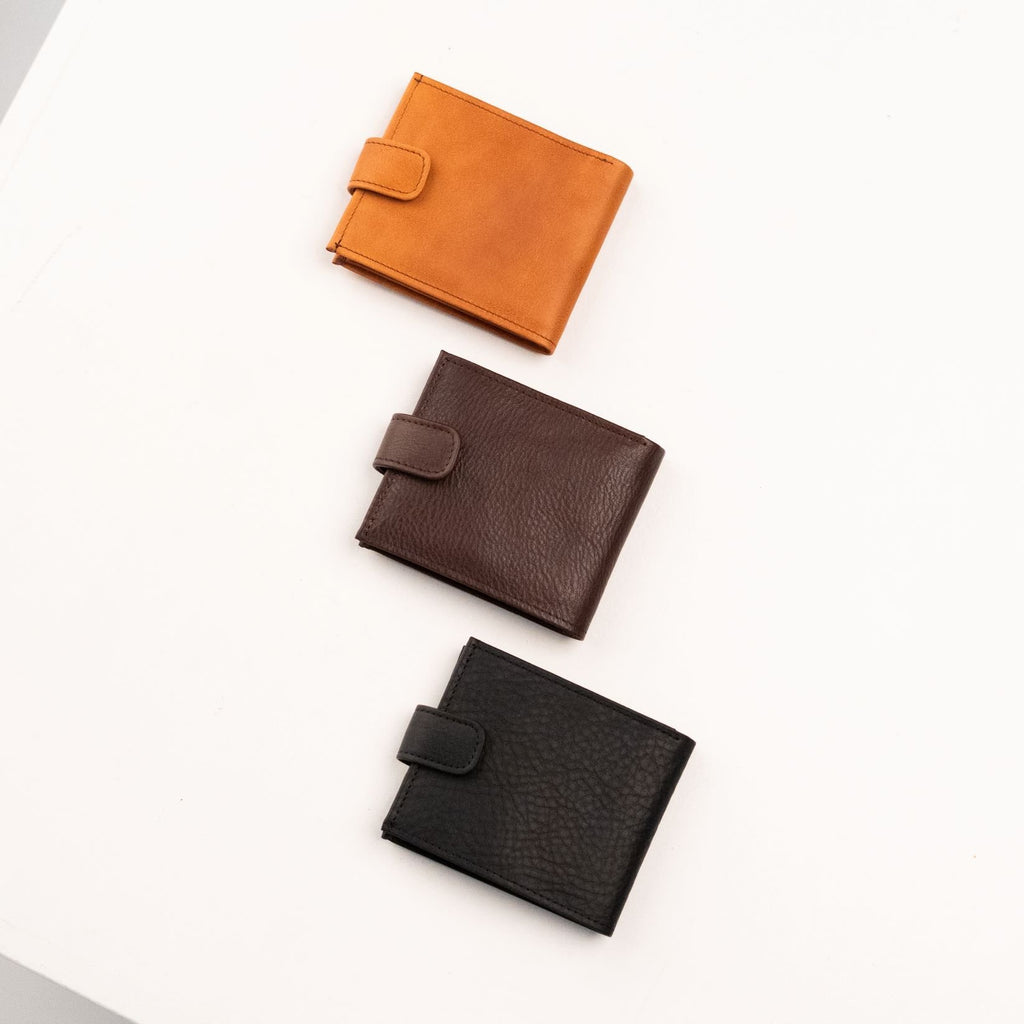 4. Flat lay of closed men's leather wallets in tan, brown, and black by Papillon, highlighting texture and clasp